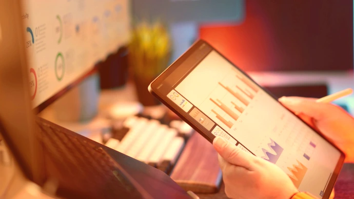 Someone analyzes financial data on a tablet